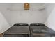 Modern laundry room featuring side-by-side appliances and overhead shelving for storage at 2626 Peachtree Nw Rd # 1108, Atlanta, GA 30305