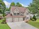 Aerial view of a lovely two-story home with a three-car garage and manicured lawn at 3260 Caney Creek Ln, Cumming, GA 30041