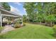 Spacious backyard featuring a covered patio with outdoor kitchen and a well-maintained lawn at 3260 Caney Creek Ln, Cumming, GA 30041