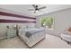 Comfortable bedroom with carpet, a window providing natural light, and striped accent wall at 3260 Caney Creek Ln, Cumming, GA 30041