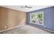 Bright bedroom with tan and blue accent walls and large window overlooking the backyard at 3260 Caney Creek Ln, Cumming, GA 30041