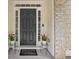 Welcoming front entrance featuring a stylish black door and decorative potted flowers at 3260 Caney Creek Ln, Cumming, GA 30041
