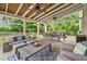 Spacious covered patio with ceiling fans, outdoor seating, and a view of the landscaped yard at 3260 Caney Creek Ln, Cumming, GA 30041