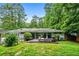 Back exterior view of the home featuring a deck, lawn, mature trees, and privacy at 3317 Embry Hills Dr, Atlanta, GA 30341