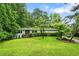 Charming single-story home featuring lush green lawn and mature trees, creating a serene curb appeal at 3317 Embry Hills Dr, Atlanta, GA 30341