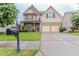 Beautiful two-story home featuring a stone facade, front porch, two-car garage, and well-manicured lawn at 3758 Lake Haven Way, Atlanta, GA 30349