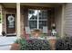 Inviting covered front porch with brick, seating, and a decorative wreath on the front door at 5230 Centennial Hill Nw Dr, Acworth, GA 30102
