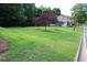 Expansive green lawn dotted with ornamental trees, enhancing the property's curb appeal at 5230 Centennial Hill Nw Dr, Acworth, GA 30102