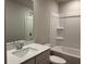 Neutrally decorated bathroom with a single sink vanity and shower/tub combo with tiled surround at 2409 Malster Ln, Lawrenceville, GA 30043