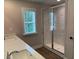 Bright bathroom features a double sink vanity, large window, and spacious glass enclosed shower at 2409 Malster Ln, Lawrenceville, GA 30043