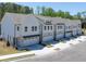 Rows of new construction townhomes feature multiple car garages and modern architectural details at 2409 Malster Ln, Lawrenceville, GA 30043