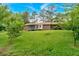 Expansive backyard featuring a well-maintained lawn, screened porch, and mature trees, ideal for outdoor activities and relaxation at 597 Rich Davis Rd, Hiram, GA 30141