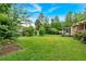 Lush backyard with expansive lawn, mature trees, and a detached garage, offering ample space and privacy at 597 Rich Davis Rd, Hiram, GA 30141