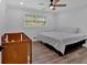 Bright bedroom featuring a window, ceiling fan, crib, and bed at 597 Rich Davis Rd, Hiram, GA 30141