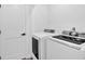 Close-up of a laundry room with a modern white washer and dryer next to a white door at 597 Rich Davis Rd, Hiram, GA 30141