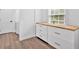 Bright laundry room features sleek white cabinets, butcher block countertop and a window that provides natural light at 597 Rich Davis Rd, Hiram, GA 30141