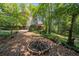 Backyard of the home includes a fire pit area and lush landscaping at 6360 Lakeview Ter, Douglasville, GA 30135
