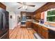 Well-lit kitchen with wood cabinets, stainless appliances, black refrigerator and wood-look flooring at 6360 Lakeview Ter, Douglasville, GA 30135