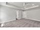 Spacious bedroom featuring carpet, tray ceilings, and an open doorway at 2413 Malster Ln, Lawrenceville, GA 30043