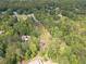 Aerial view of a wooded property showcasing a mix of trees and open spaces, near residential area at 1623 Pratt Rd, Covington, GA 30014