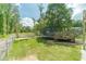 Grassy backyard with a trampoline, wooden deck, and fence, creating a secure and enjoyable outdoor space at 1623 Pratt Rd, Covington, GA 30014