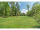 Large, green backyard with trees in the background, offering plenty of space for outdoor activities and privacy at 1623 Pratt Rd, Covington, GA 30014