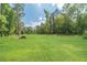 Large, green backyard with trees surrounding the property, offering plenty of space for outdoor activities at 1623 Pratt Rd, Covington, GA 30014