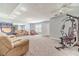 Large finished basement featuring carpeted flooring, multiple seating areas, and exercise equipment at 1623 Pratt Rd, Covington, GA 30014