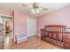 Cozy bedroom featuring a crib, ceiling fan, closet, and stylish wood laminate flooring at 1623 Pratt Rd, Covington, GA 30014