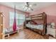 This cozy bedroom boasts a ceiling fan, bunkbed, and wood laminate flooring at 1623 Pratt Rd, Covington, GA 30014