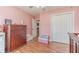 A charming pink bedroom features wood laminate flooring, a ceiling fan, and ample closet space at 1623 Pratt Rd, Covington, GA 30014