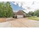 Side view of a home featuring an attached two-car garage and a large concrete driveway at 1623 Pratt Rd, Covington, GA 30014
