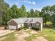 Aerial front view of a charming brick home with a two-car garage, manicured lawn, and lots of trees at 1623 Pratt Rd, Covington, GA 30014