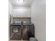 Laundry room showcasing modern front-loading washer and dryer and ample storage space at 1623 Pratt Rd, Covington, GA 30014