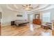 Large main bedroom with tray ceiling, wood floors, ceiling fan, and sitting area at 1623 Pratt Rd, Covington, GA 30014