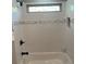 Tiled shower and tub combo with glass enclosure and overhead shower head at 2668 Memorial Se Dr, Atlanta, GA 30317