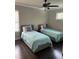 Bright bedroom featuring two twin beds with matching bedding and a ceiling fan at 2668 Memorial Se Dr, Atlanta, GA 30317