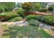 A landscaped back yard with stone steps and a red fence at 115 Windover Ct, Roswell, GA 30075