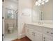 Well-lit bathroom featuring a white vanity, a large mirror, and a separate shower area at 115 Windover Ct, Roswell, GA 30075