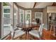 Dining area with a dark wood table, light wood paneling and large windows offering an abundance of light at 115 Windover Ct, Roswell, GA 30075