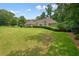 Expansive green front lawn with a neatly manicured property and stone accents at 115 Windover Ct, Roswell, GA 30075