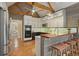 Eat-in kitchen features stainless appliances, custom cabinets, and a breakfast bar with wood accents at 115 Windover Ct, Roswell, GA 30075