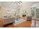Bright living room with fireplace, neutral decor, and French doors to a screened porch at 115 Windover Ct, Roswell, GA 30075