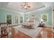Spacious main bedroom with trey ceiling, light blue walls, hardwood floors, and multiple windows for natural light at 115 Windover Ct, Roswell, GA 30075