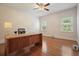 Bright office space features a ceiling fan, hardwood floors, a large desk, and natural light from two windows at 115 Windover Ct, Roswell, GA 30075