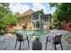 Outdoor pool with a stone waterfall feature and chair seating at 115 Windover Ct, Roswell, GA 30075