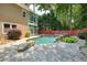 Backyard pool area with mature trees, a small rock waterfall, and large patio at 115 Windover Ct, Roswell, GA 30075