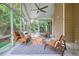 A spacious screened porch with views of the lush backyard. Comfortable seating for relaxing and enjoying nature at 115 Windover Ct, Roswell, GA 30075