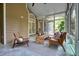 A screened porch with comfortable furniture. French doors connect to the home's interior at 115 Windover Ct, Roswell, GA 30075