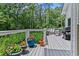 Well-maintained back deck with a white railing, grill, and natural wooded background provides serene outdoor enjoyment at 25 Highlands Way, Oxford, GA 30054